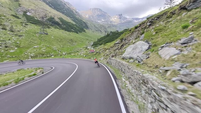 Cyclist rides along a winding mountain road with stunning views. Perfect for travel, sports, or adventure themes. High-quality footage.