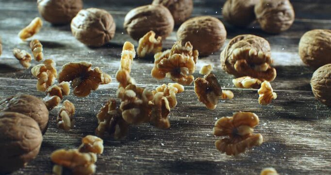 Cracked Walnut in Mid-Air with Broken Kernel Falling on Wooden Surface Slow Motion Close-Up Capturing Nut Explosion, Texture, and Organic Motion in Rustic Food Setting at 1000 fps.
