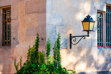 Lamp on the corner of a house with ivy and inscription in Bebenhausen Monastery (Tübingen,...