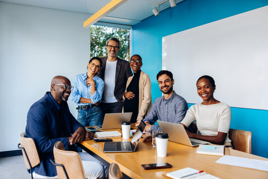 Diverse group of professionals smiling during a meeting in an office setting - Powered by Adobe