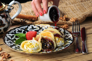 pancakes with jam, cream and preserves, rolled up and drizzled with jam