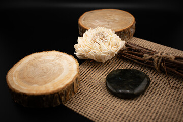 Polished labradorite with iridescent blue-green hues rests on a wooden slice beside rustic twigs tied with jute. Perfect for wellness, meditation, crystal healing, and earthy lifestyle concepts.