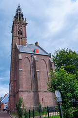Beautiful Leaning Carillon Tower (De Speeltoren) of the old Church of Our Lady, tilting over Kleine Kerkstraat. The tower was constructed in the 15th and 16th centuries. EDAM, NETHERLANDS.