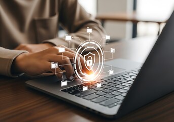 Person using laptop with digital shield symbol for data security