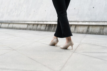 woman wearing high heels walking on the road