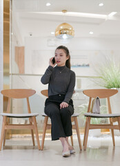 Beautiful woman sitting outside the restaurant and talking on her cell phone