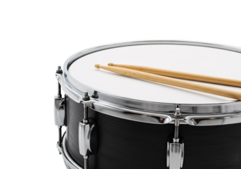 Close up of a black snare drum with wooden drumsticks resting on its white head isolated on transparent background