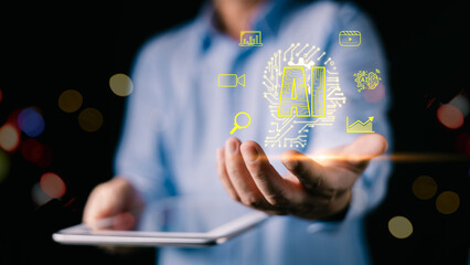 A man in a blue shirt holds a tablet while projecting glowing yellow AI icons, symbolizing digital innovation, data analysis, and futuristic technology.A dark bokeh background enhances contrast.