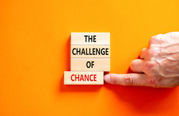 The challenge of chance symbol. Concept words phrase The challenge of chance on beautiful wooden blocks. Beautiful orange paper background. Business The challenge of chance concept. Copy space.