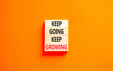 Keep going and growing symbol. Concept words phrase Keep going keep growing on beautiful wooden blocks. Beautiful orange paper background. Business Keep going and growing concept. Copy space.