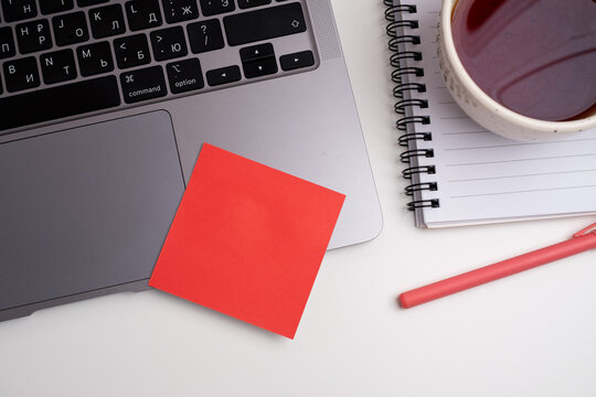 Office desk with red sticker, coffee and laptop. Office and work concept. Flat lay top view with copy space.