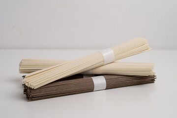 Packet of dry soba, raw buckwheat and rice noodles, uncooked buckwheat pasta, gluten free soba spaghetti on white background.