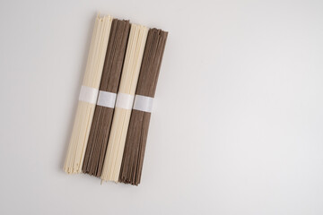 Packet of dry soba, raw buckwheat and rice noodles, uncooked buckwheat pasta, gluten free soba spaghetti on white background.