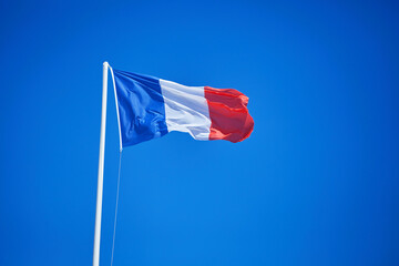 French flag on the bright solid fond plain blue sky background