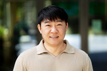 Asian businessman smiling outside office building