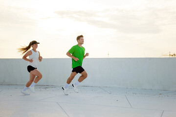 Jogging on a rooftop at sunset in vibrant urban setting