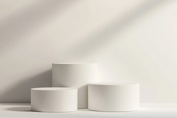 Three white cylindrical pedestals arranged in a staggered formation isolated on a transparent background