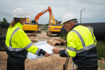 The survey team is using a theodolite and road construction plans. Civil engineers are measuring...