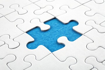 Fototapeta premium White Puzzle Pieces with Missing Piece on Blue Background Surface