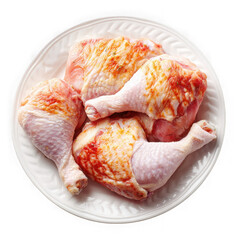 Raw chicken pieces seasoned and prepared for cooking on a white plate isolated on transparent background