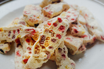 Closeup image of a full plate of delicious homemade sweet nougat cookies on a white plate for celebration and party