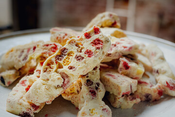 Closeup image of a full plate of delicious homemade sweet nougat cookies on a white plate for celebration and party
