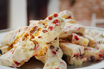 Closeup image of a full plate of delicious homemade sweet nougat cookies on a white plate for celebration and party