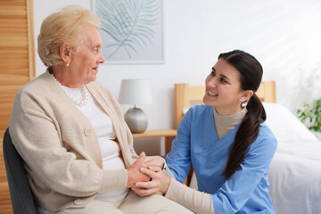 Nurse assisting senior woman indoors. Home health care service