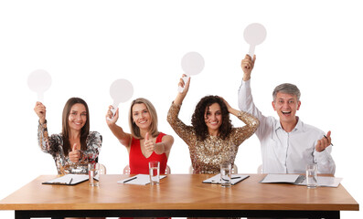 Panel of happy judges with blank score signs at table on white background