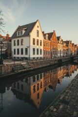 Fototapeta premium Charming Dutch canal lined with historic gabled houses at sunset