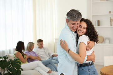 Happy friends hugging at home, selective focus