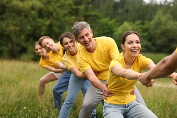 Team building. Group of happy people holding hands outdoors