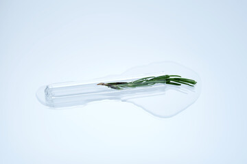 A test tube with rosemary inside and a cosmetic texture.
