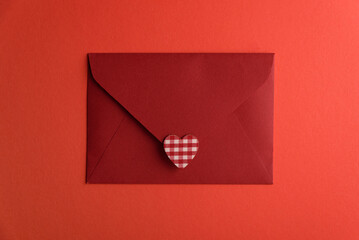 Close red envelope witl love letter and hearts on red background. Valentines day celebration