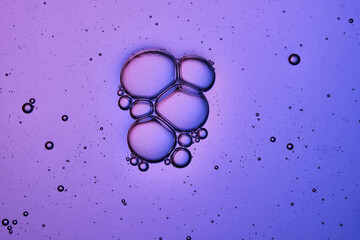 Bubbles in shampoo or shower gel. Texture on a purple background.