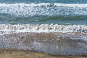High shutter speed to freeze the motion of waves crashing onto a sandy beach on the Isle of Wight