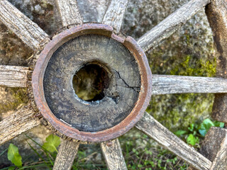 Macro Detail of an Old, Cracked Wooden Wagon Wheel Leaning Against a Stone Wall