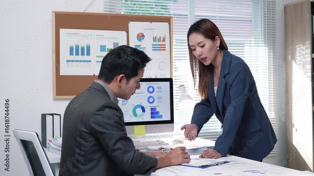 Poster business partners discussing financial charts and graphs displayed on a computer screen and printed 
