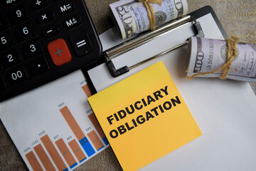 Concept of Fiduciary obligation write on sticky notes isolated on Wooden Table.