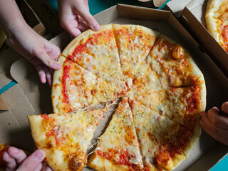 Friends sharing freshly baked pizza over a casual gathering at home