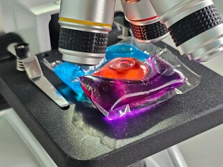 Microscopic examination of colorful gel like materials on a laboratory microscope stage at a...