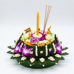 Traditional Krathong with Candle, Flag and Incense Sticks.
A beautifully decorated krathong with flowers, a candle, incense, and small Thai flag, ready for Loy Krathong festival.

