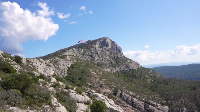 Man Hang Gliding Action Sports in Sainte Victoire Aix-en-Provence France Mountain. Adrenaline Adventure Sunny Day Nature Outside Pink Parachute