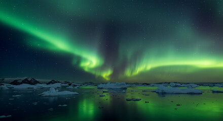 Naklejka premium A mesmerizing display of the aurora borealis over a serene landscape with icebergs and water reflections