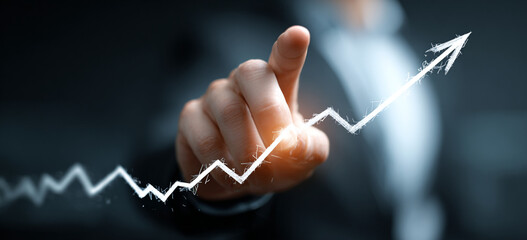 Businessman touching a glowing upward arrow graph symbolizing business growth, success, and financial progress

