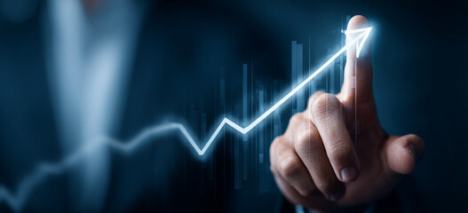 Businessman touching a glowing upward arrow graph symbolizing business growth, success, and financial progress


