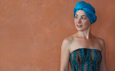Portrait of a beautiful east woman with a turban on orange wall background.