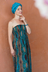 Portrait of a beautiful east woman with a turban on orange wall background.