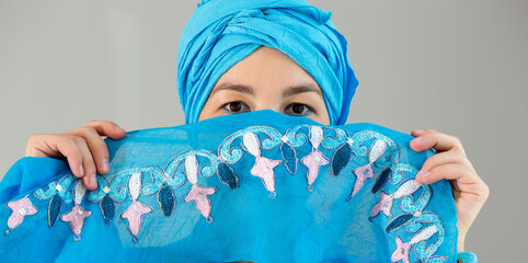 Close up woman sight. Young woman in oriental blue dress. Eastern dance. Cover face.