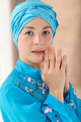 Portrait of a beautiful young woman. A woman in blue colored clothes of the east asian type.